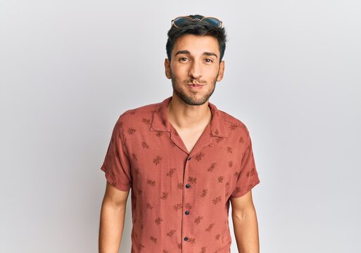 Young handsome man wearing casual summer clothes puffing cheeks with funny face. mouth inflated with air, crazy expression.