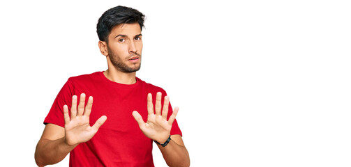 Young handsome man wearing casual red tshirt moving away hands palms showing refusal and denial...