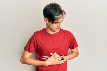 Young hispanic man wearing casual clothes with hand on stomach because indigestion, painful illness feeling unwell. ache concept.