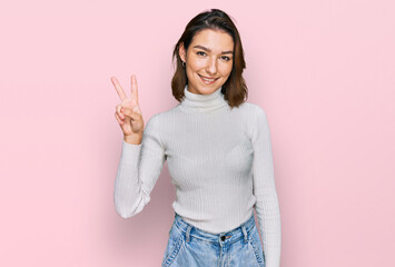 Young caucasian girl wearing casual clothes showing and pointing up with fingers number two while smiling confident and happy.