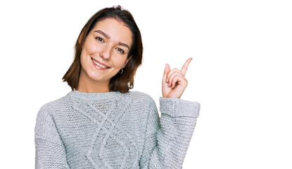 Young caucasian girl wearing casual clothes with a big smile on face, pointing with hand and finger to the side looking at the camera.