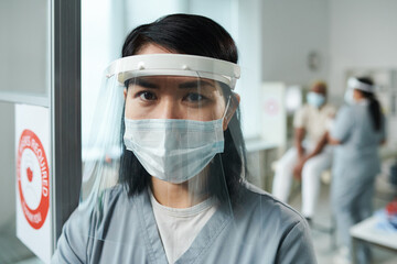 Fototapeta na wymiar Young nurse or clinician in protective workwear standing in front of camera
