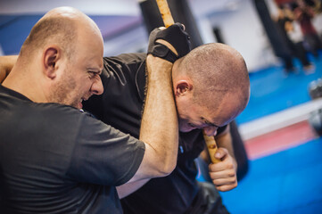 Instructor and student practice filipino escrima stick fighting technique
