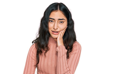 Hispanic teenager girl with dental braces wearing casual clothes touching mouth with hand with painful expression because of toothache or dental illness on teeth. dentist