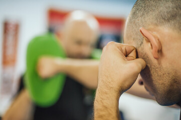Instructor holds focus mitts. Boxing kick training and demonstration