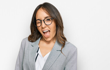Young brunette woman wearing business clothes winking looking at the camera with sexy expression,...