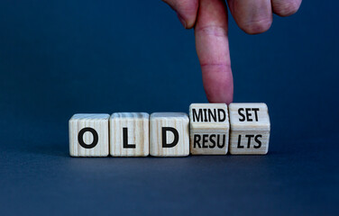 Old mindset and results symbol. Businessman turns wooden cubes and changes words 'old mindset' to 'old results'. Beautiful grey background. Business, old mindset and results concept. Copy space.