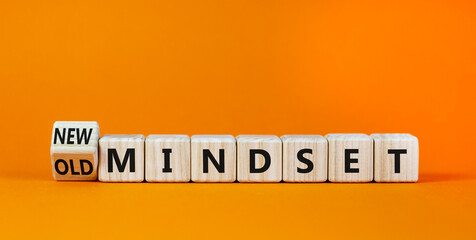 New vs old mindset symbol. Turned the wooden cube and changed words 'old mindset' to 'new mindset'. Beautiful orange background. Business, new or old mindset concept. Copy space.