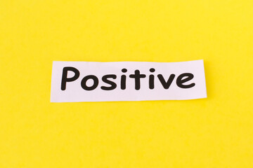 Word positive written on white paper . The concept of positive