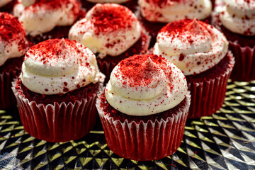 red velvet mini cupcakes each topped with a swirl of vanilla frosting sprinkled with red sugar