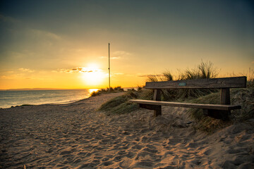 Naklejka na ściany i meble bench on the beach with sunset