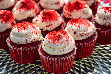 red velvet mini cupcakes each topped with a swirl of vanilla frosting sprinkled with red sugar