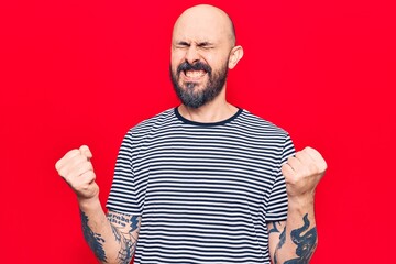 Naklejka premium Young handsome man wearing casual clothes very happy and excited doing winner gesture with arms raised, smiling and screaming for success. celebration concept.