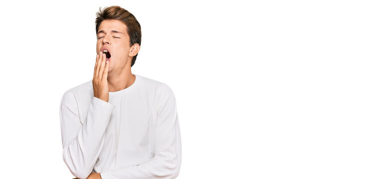 Handsome caucasian man wearing casual white sweater bored yawning tired covering mouth with hand. restless and sleepiness.