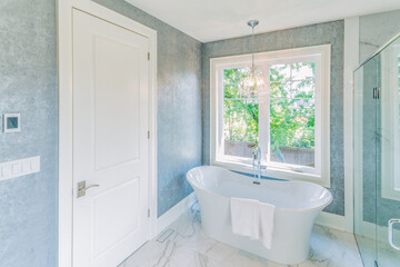 Modern design bathroom with free standing tub topped with a chandelier
