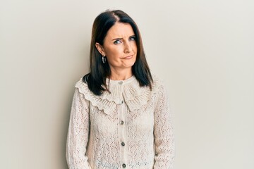 Middle age brunette woman wearing casual clothes skeptic and nervous, frowning upset because of...