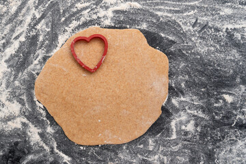 Heart shaped dough and cookie cutters. Cookies making process.