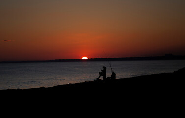 fishermen at the beach at sunset