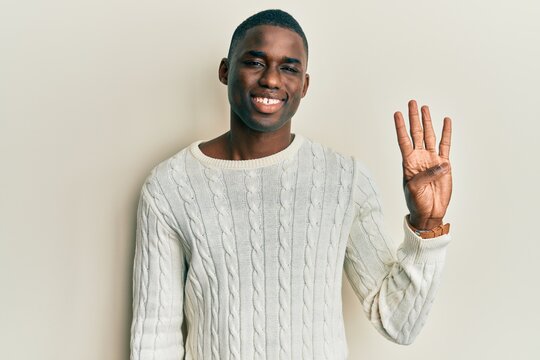 Young african american man wearing casual clothes showing and pointing up with fingers number four while smiling confident and happy.