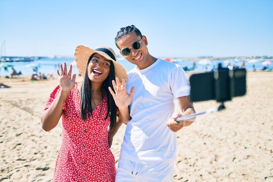 Young latin couple smiling happy making selfie by the smartphone at the beach.