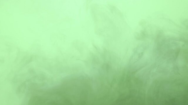 Dark ink spreading in green-blue water. Abstract color background, liquid smoke effect, psychedelic and art concept.