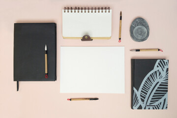 Blank sheet mockup, notepads and calligraphy brushes. Top view: Attributes for calligraphy. Flatley harmoniously laid out objects.