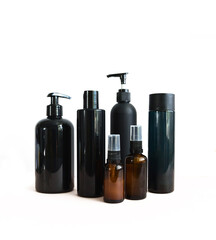 Black cosmetic bottles isolated on white. Plastic containers of various sizes for cosmetics.