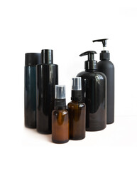 Black cosmetic bottles isolated on white. Plastic containers of various sizes for cosmetics.