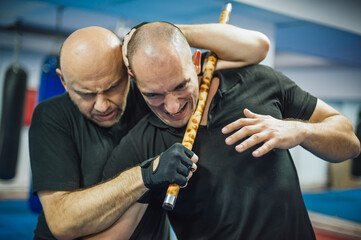 Instructor and student practice filipino escrima stick fighting technique