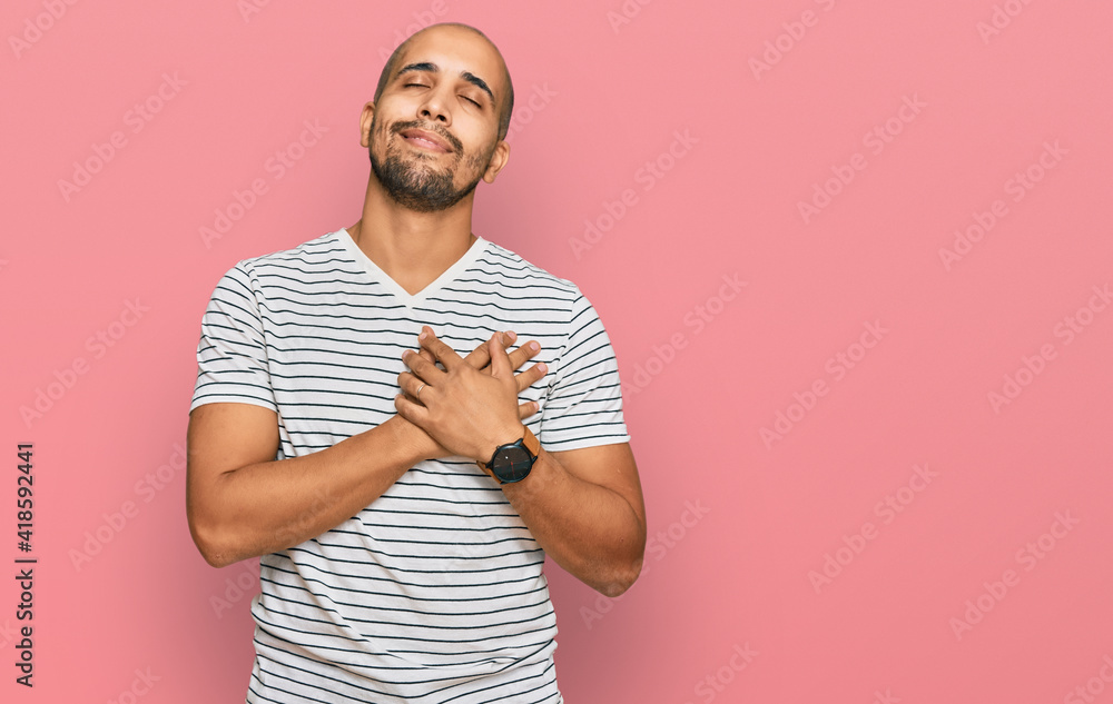 Canvas Prints Hispanic adult man wearing casual clothes smiling with hands on chest with closed eyes and grateful gesture on face. health concept.