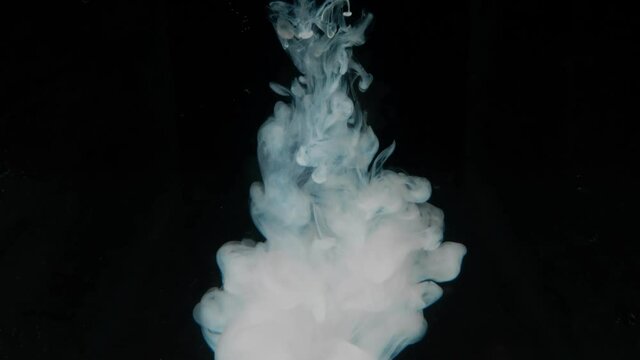 Abstract background. White paint dissolves in water on a black background. copy space.