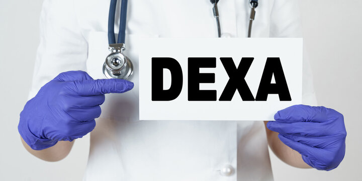 The doctor points his finger at a sign that says - DEXA