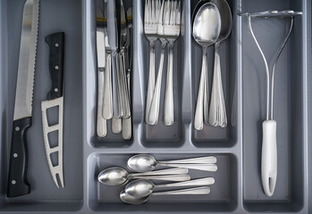 Set of cutlery in kitchen drawer, above view.