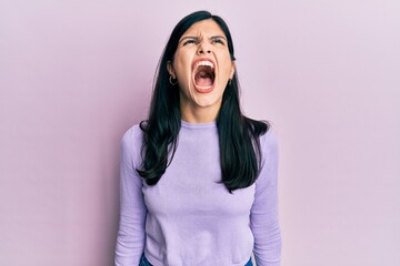 Young hispanic woman wearing casual clothes angry and mad screaming frustrated and furious, shouting with anger. rage and aggressive concept.