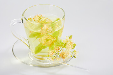 Transparent glass cup of tea with linden isolated on white