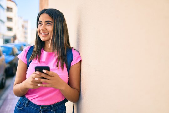 Young latin student girl smiling happy using smartphone at university campus.