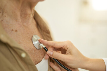 Healthcare professional checking heart and lungs of man with stethoscope