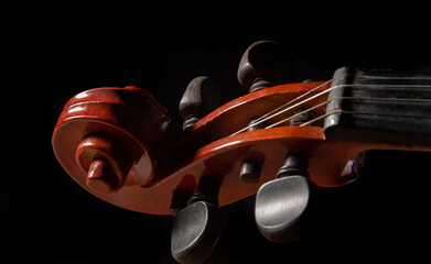 Violin, details of a beautiful violin on wooden surface and black background, low key selective...