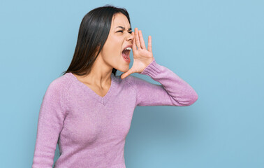 Young hispanic girl wearing casual clothes shouting and screaming loud to side with hand on mouth. communication concept.