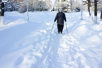 Senior at the snow in winter nordic walking
