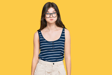 Young beautiful caucasian girl wearing casual clothes and glasses puffing cheeks with funny face. mouth inflated with air, crazy expression.