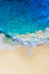 Fototapeta na wymiar Travel and vacation image. Coast as a background from top view. Blue water background from air. Summer seascape from drone. Strong waves.