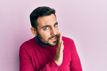Young hispanic man wearing casual clothes hand on mouth telling secret rumor, whispering malicious talk conversation
