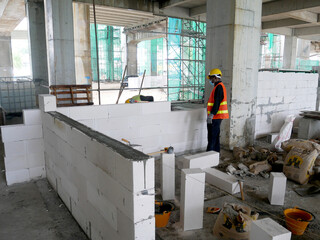 SEREMBAN, MALAYSIA -MARCH 15, 2020: Blockwork by construction workers at the construction site. Workers laying the AAC brick and stacked it together using mortar to form the wall. 