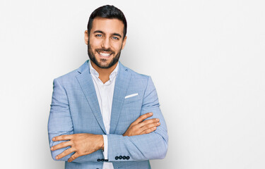 Young hispanic man wearing business jacket happy face smiling with crossed arms looking at the camera. positive person.