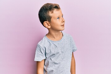 Adorable caucasian kid wearing casual clothes looking to side, relax profile pose with natural face and confident smile.