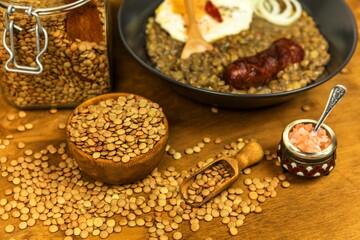 Lentils with sausage and chili. Grilled sausage and lentils with egg on a black plate. Legumes. Healthy food.