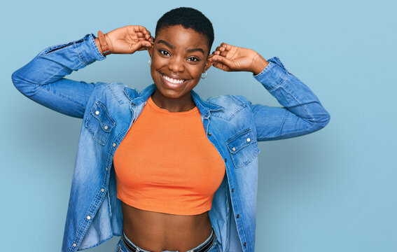 Young african american woman wearing casual clothes smiling pulling ears with fingers, funny gesture. audition problem
