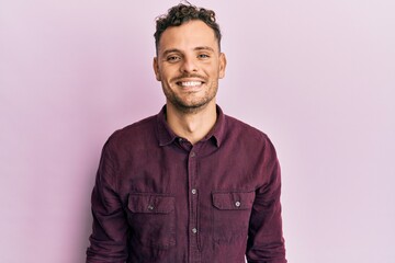 Young hispanic man wearing casual clothes with a happy and cool smile on face. lucky person.