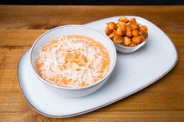 Plate of soup creme with chicken and cheese with crackers